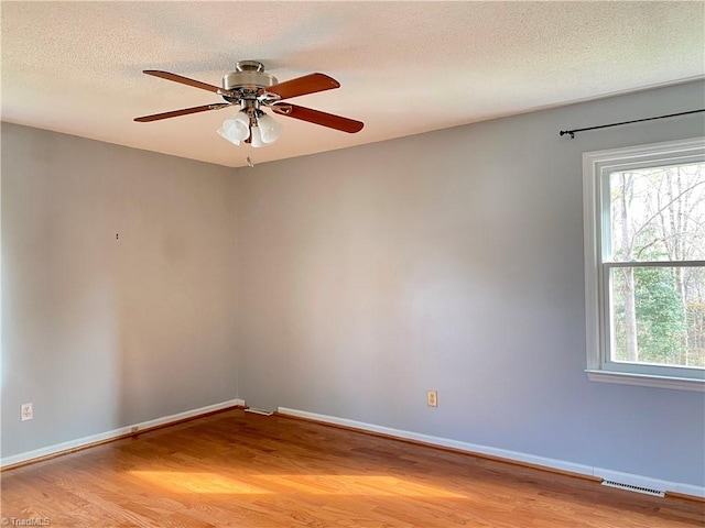 unfurnished room featuring ceiling fan, light wood-type flooring, and a textured ceiling