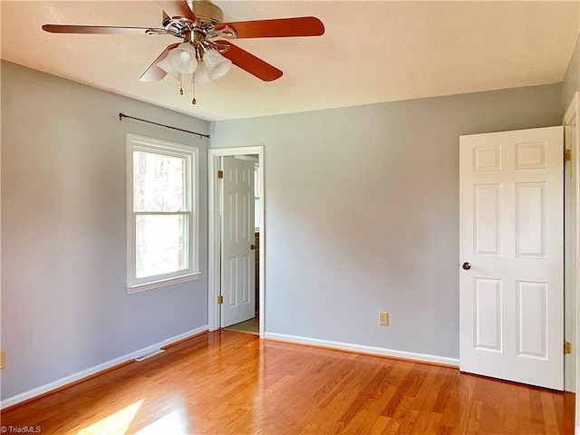 empty room with ceiling fan and light wood-type flooring