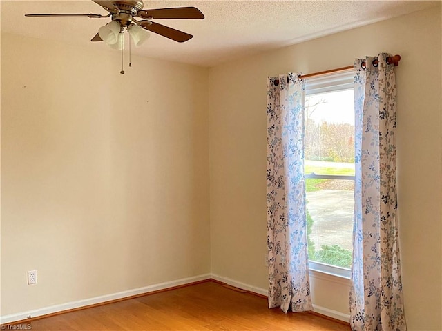 spare room with ceiling fan, wood-type flooring, and a textured ceiling