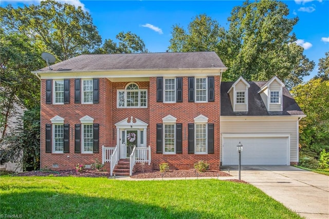 colonial inspired home featuring a garage and a front lawn