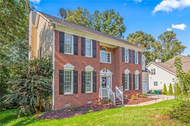 colonial inspired home with a front lawn