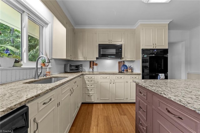 1805 Guilford College Rd, Jamestown, NC 27282 - kitchen with black appliances, a sink, light wood finished floors, light stone counters, and crown molding