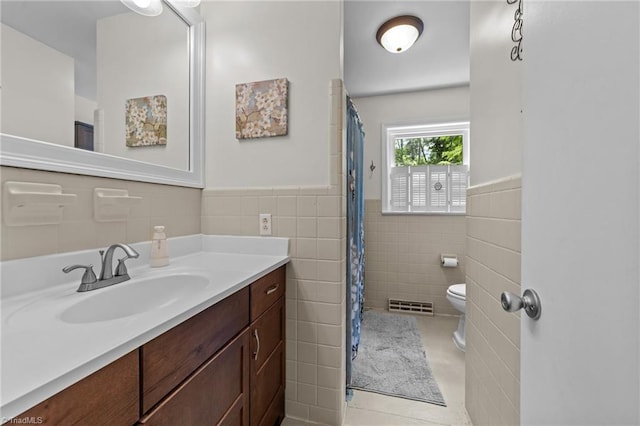 1805 Guilford College Rd, Jamestown, NC 27282 - bathroom featuring tile walls, toilet, vanity, wainscoting, and tile patterned flooring