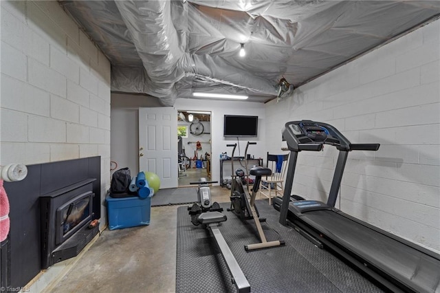 1805 Guilford College Rd, Jamestown, NC 27282 - workout area with a wood stove and concrete block wall