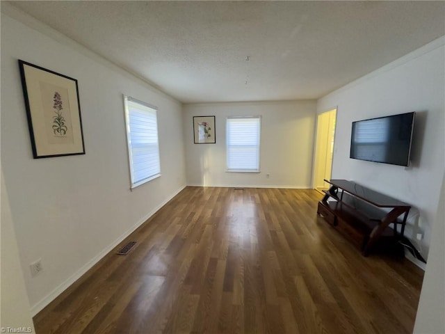 unfurnished living room with dark hardwood / wood-style floors and ornamental molding