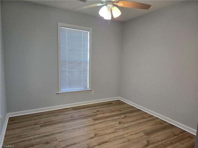 unfurnished room featuring ceiling fan, wood finished floors, and baseboards