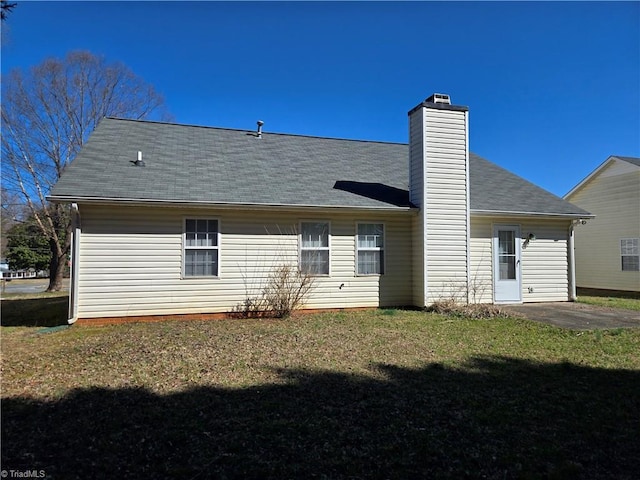 back of property featuring a yard, a chimney, and a patio