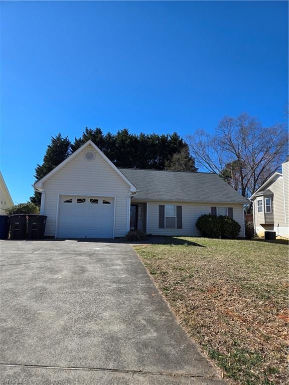 ranch-style home with driveway, a front lawn, and an attached garage