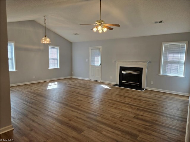 unfurnished living room featuring a fireplace, visible vents, vaulted ceiling, and dark wood-style flooring