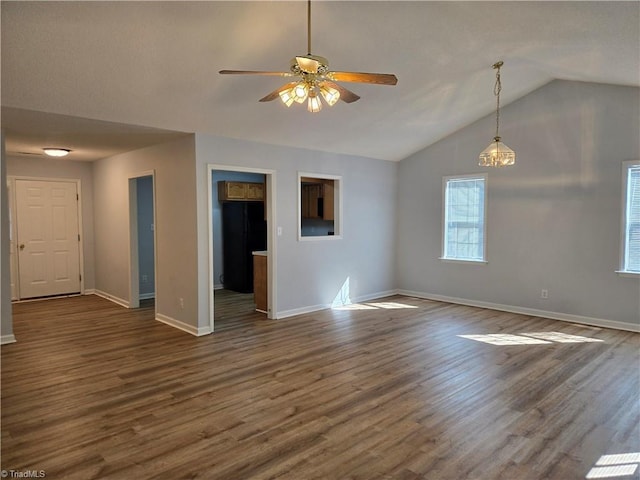 unfurnished room featuring dark wood-style floors, vaulted ceiling, baseboards, and a ceiling fan