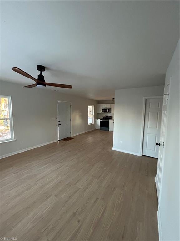 unfurnished living room with ceiling fan, a healthy amount of sunlight, and light hardwood / wood-style floors