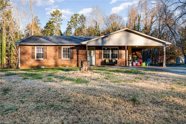 ranch-style house featuring a front lawn and a carport