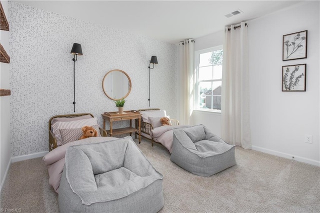 living area with baseboards, carpet flooring, visible vents, and wallpapered walls