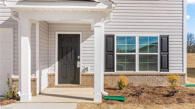 doorway to property featuring brick siding