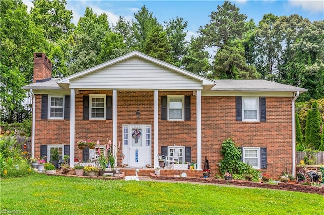 6115 Winview Heights St, Clemmons, NC 27012 - bi-level home featuring brick siding, a front yard, a chimney, a porch, and view of scattered trees