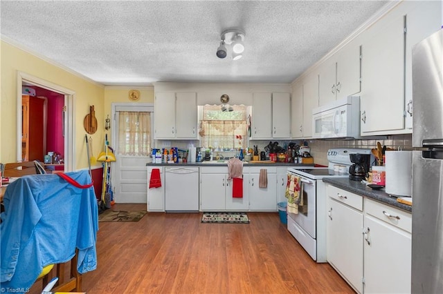 6115 Winview Heights St, Clemmons, NC 27012 - kitchen with white appliances, a textured ceiling, crown molding, dark countertops, and wood finished floors