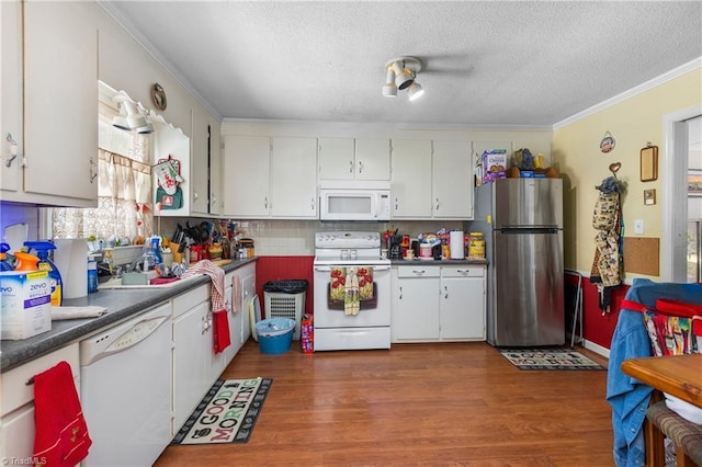6115 Winview Heights St, Clemmons, NC 27012 - kitchen with white appliances, ornamental molding, wood finished floors, tasteful backsplash, and white cabinets