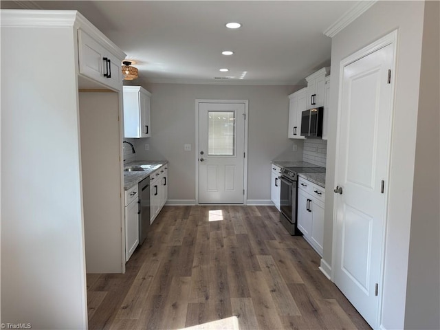 2322 Fernwood Dr, Greensboro, NC 27408 - kitchen featuring stainless steel appliances, recessed lighting, light stone counters, decorative backsplash, and wood finished floors