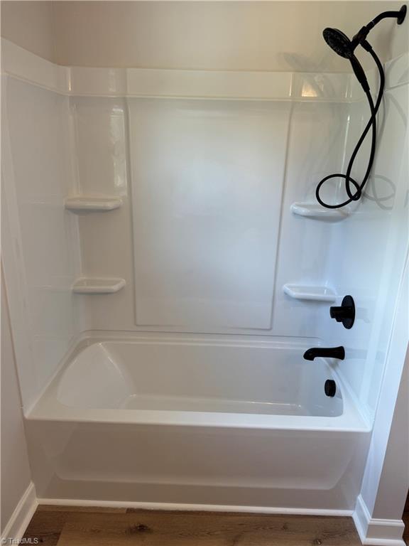 2322 Fernwood Dr, Greensboro, NC 27408 - bathroom with baseboards, wood finished floors, and tub / shower combination