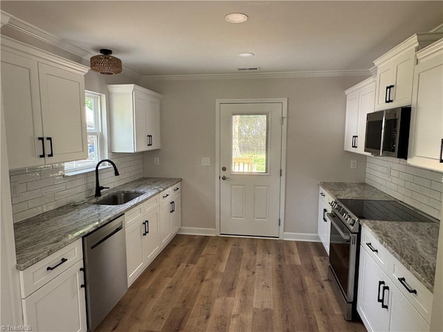 2322 Fernwood Dr, Greensboro, NC 27408 - kitchen with appliances with stainless steel finishes, a sink, light stone counters, white cabinetry, and ornamental molding