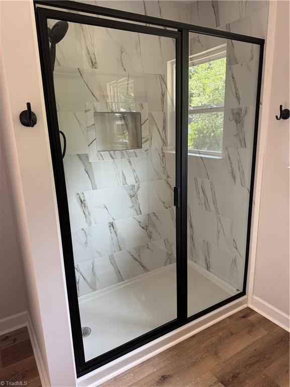 2322 Fernwood Dr, Greensboro, NC 27408 - full bathroom with a marble finish shower, baseboards, and wood finished floors