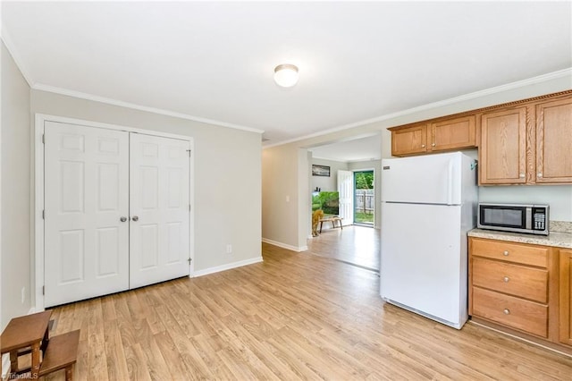 78 Arnies Ln, Sparta, NC 28675 - kitchen featuring freestanding refrigerator, stainless steel microwave, brown cabinets, light wood finished floors, and crown molding