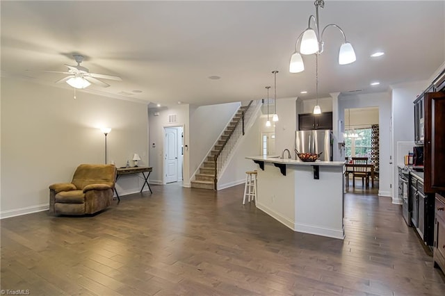 4116 Branch Point Ct, Pfafftown, NC 27040 - kitchen with appliances with stainless steel finishes, ornamental molding, ceiling fan, a breakfast bar, and baseboards