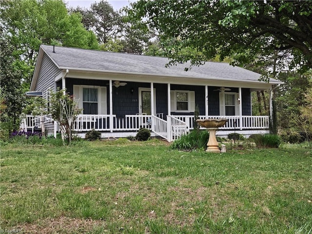 ranch-style home with a ceiling fan, roof with shingles, a front lawn, and covered porch