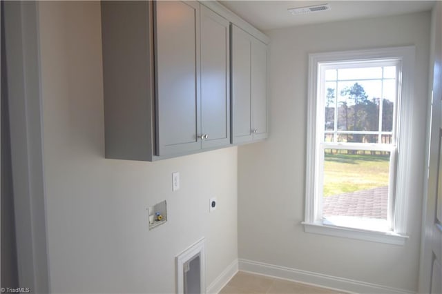 washroom with hookup for an electric dryer, hookup for a washing machine, light tile patterned floors, and cabinets