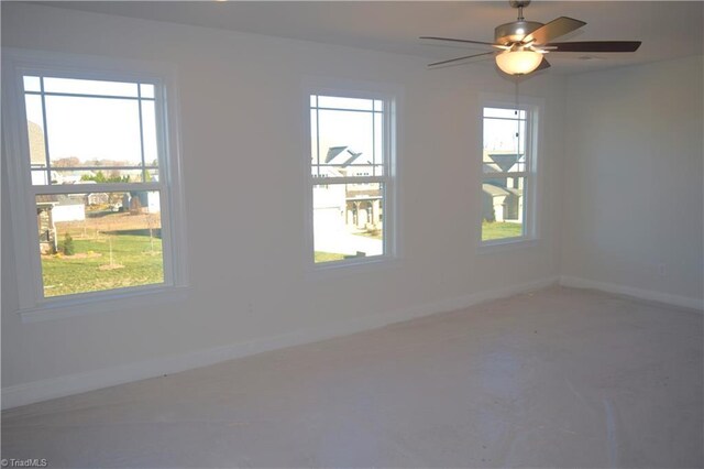 unfurnished room with ceiling fan and a healthy amount of sunlight