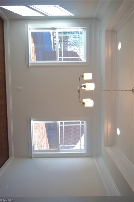 bathroom with a chandelier and crown molding