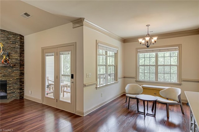 living area with a notable chandelier, a wealth of natural light, and wood finished floors
