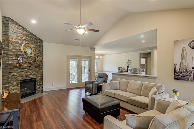 living area with a fireplace, high vaulted ceiling, ceiling fan with notable chandelier, wood finished floors, and visible vents