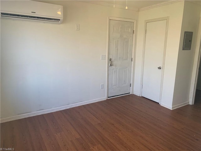 744 Caleb St, Eden, NC 27288 - empty room featuring a wall unit AC, dark wood-type flooring, baseboards, electric panel, and ornamental molding