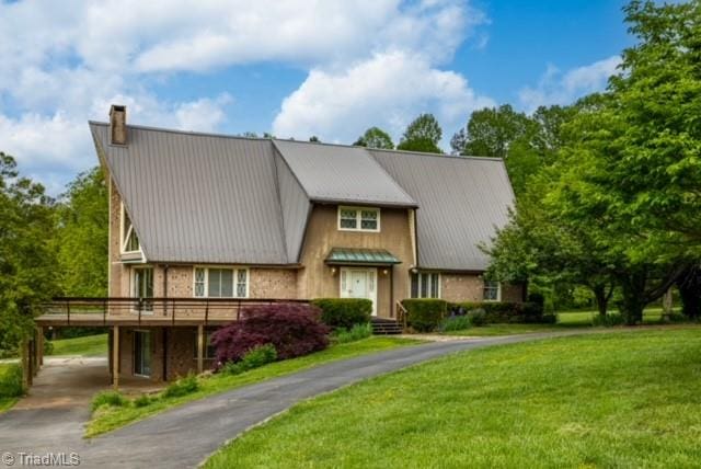 townhome / multi-family property with a wooden deck and a front yard