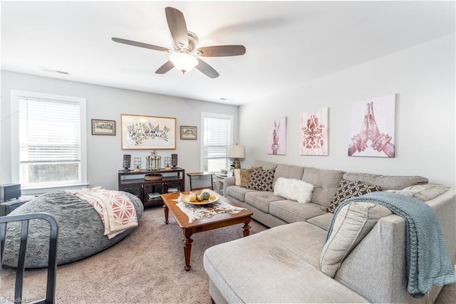 living area featuring carpet flooring and a ceiling fan