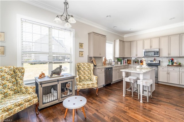 kitchen featuring a sink, a kitchen island, stainless steel appliances, crown molding, and dark wood-style flooring