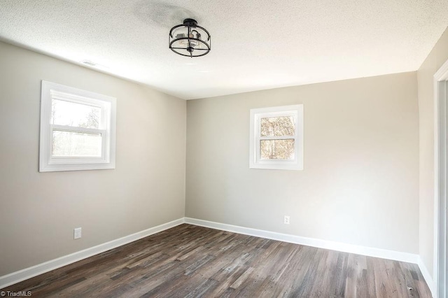 unfurnished room with dark wood-type flooring and a textured ceiling