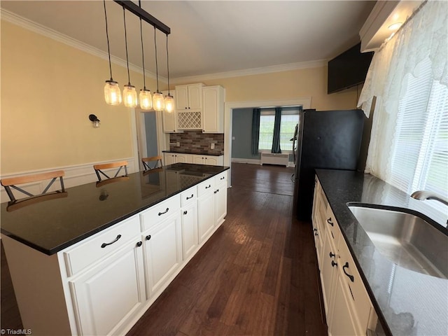 216 Rawley Ave, Mount Airy, NC 27030 - kitchen featuring a sink, backsplash, white cabinets, crown molding, and dark wood finished floors