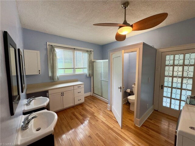 216 Rawley Ave, Mount Airy, NC 27030 - full bathroom featuring a stall shower, a textured ceiling, toilet, wood-type flooring, and a ceiling fan