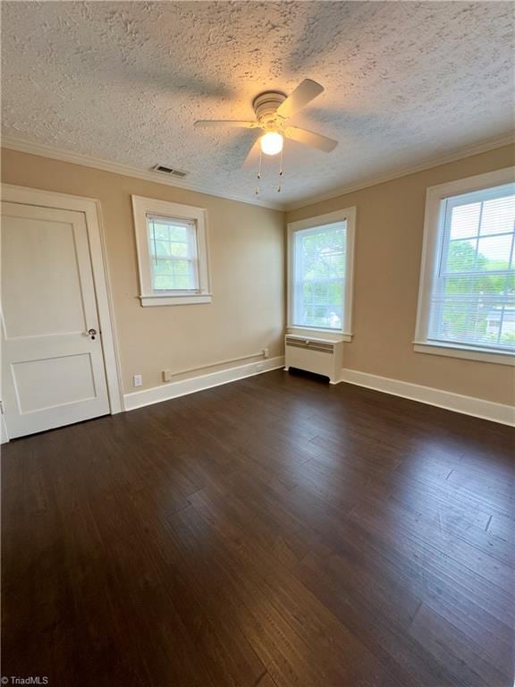 216 Rawley Ave, Mount Airy, NC 27030 - empty room with a textured ceiling, healthy amount of natural light, dark wood finished floors, crown molding, and a ceiling fan