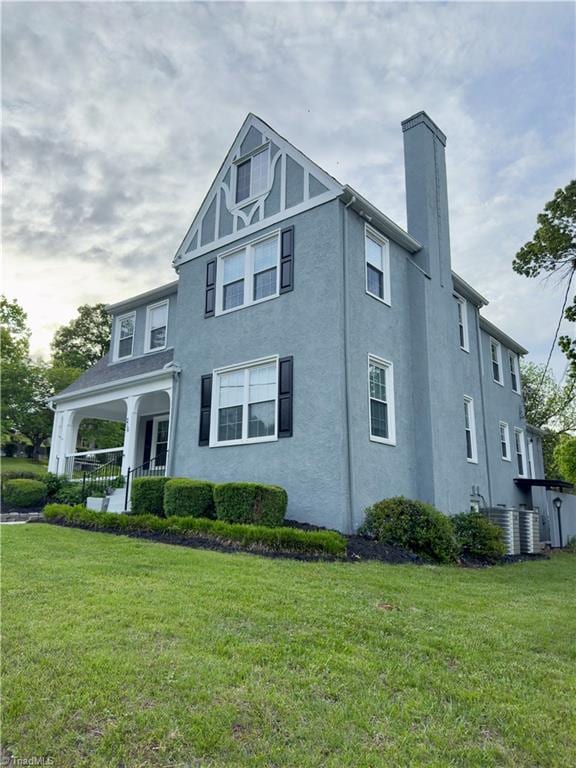 216 Rawley Ave, Mount Airy, NC 27030 - view of front of home featuring a chimney, a front yard, stucco siding, and covered porch