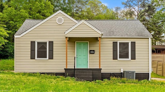 bungalow-style home featuring roof with shingles and central AC