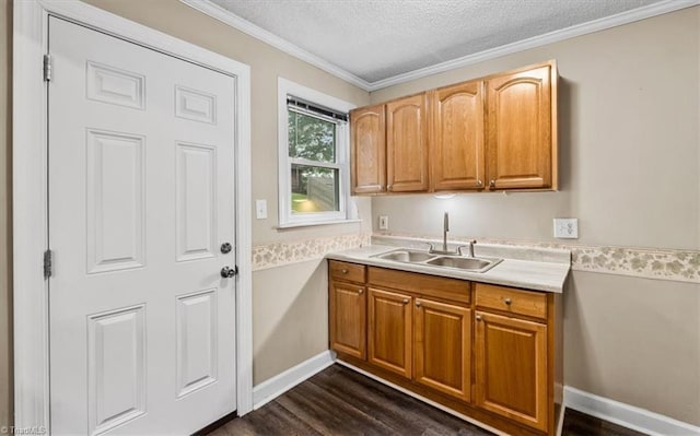 laundry room featuring crown molding, a sink, a textured ceiling, dark wood finished floors, and baseboards