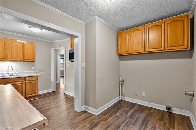 laundry area featuring cabinet space, a sink, dark wood-style floors, and a textured ceiling