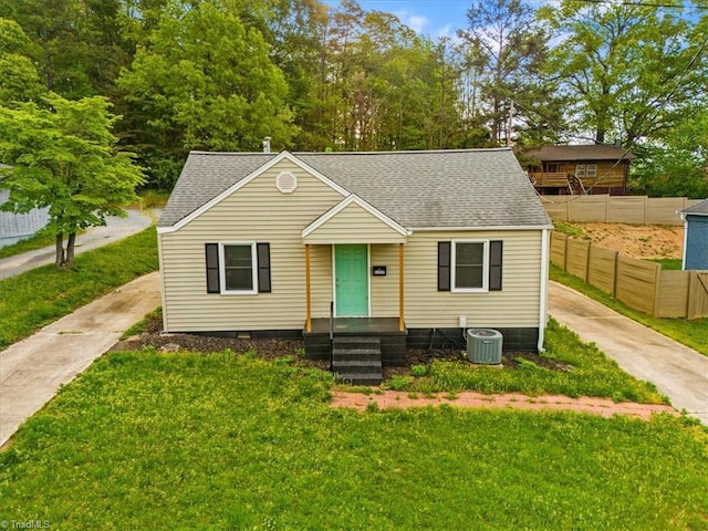 bungalow-style house with a front lawn and roof with shingles
