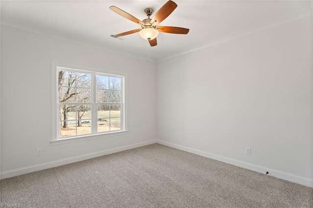 carpeted spare room featuring ceiling fan, ornamental molding, and baseboards