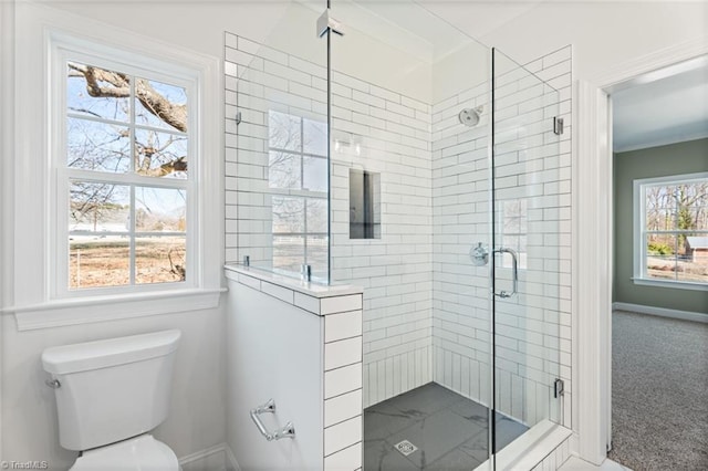 full bath with toilet, a stall shower, baseboards, and ornamental molding