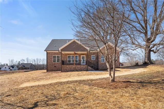 view of front of home with crawl space and brick siding