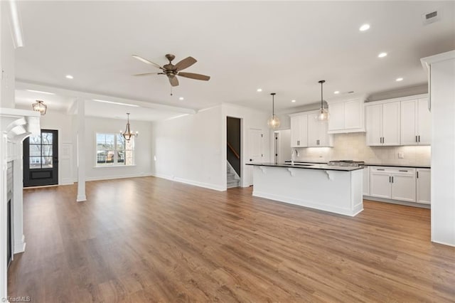 kitchen with dark countertops, white cabinets, and open floor plan